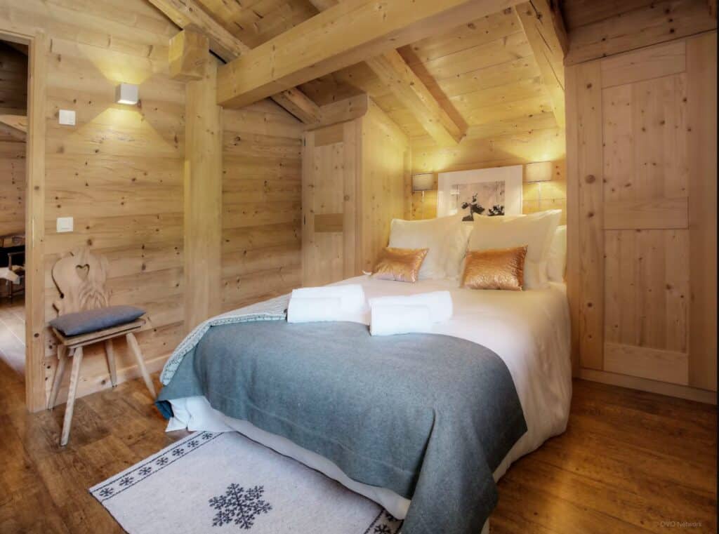 the bedroom with a double bed, cushions and a throw