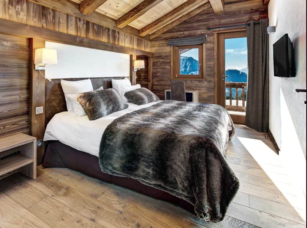 Bedroom with dark grey fluffy throw and mountain views