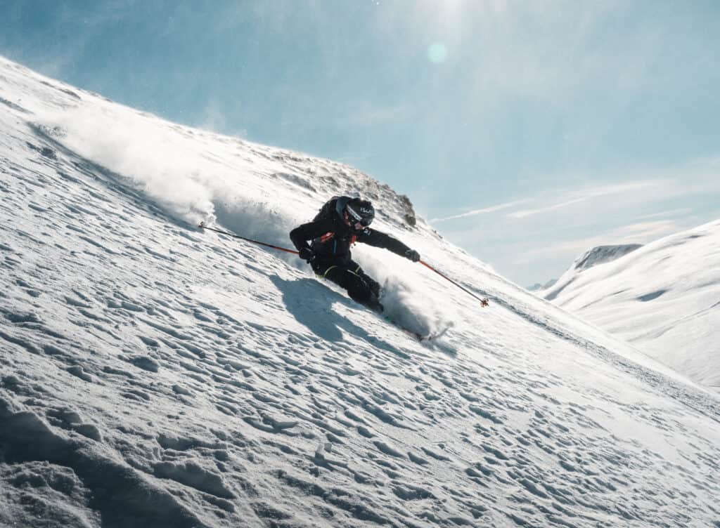 A freeride skier taking a curve.