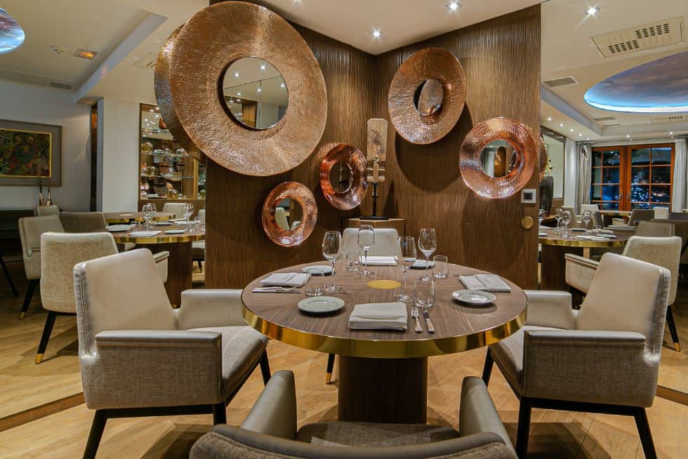 Large round mirrors on the walls and round tables in the dining room