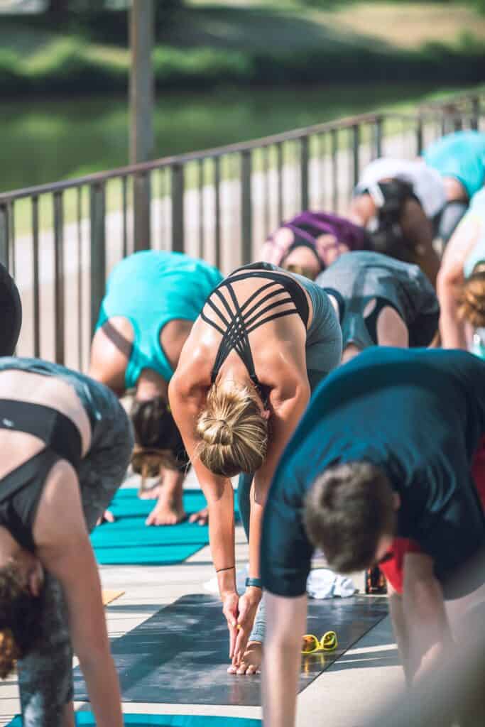 Un groupe de personne faisant des étirements lors d'un cours de yoga. 