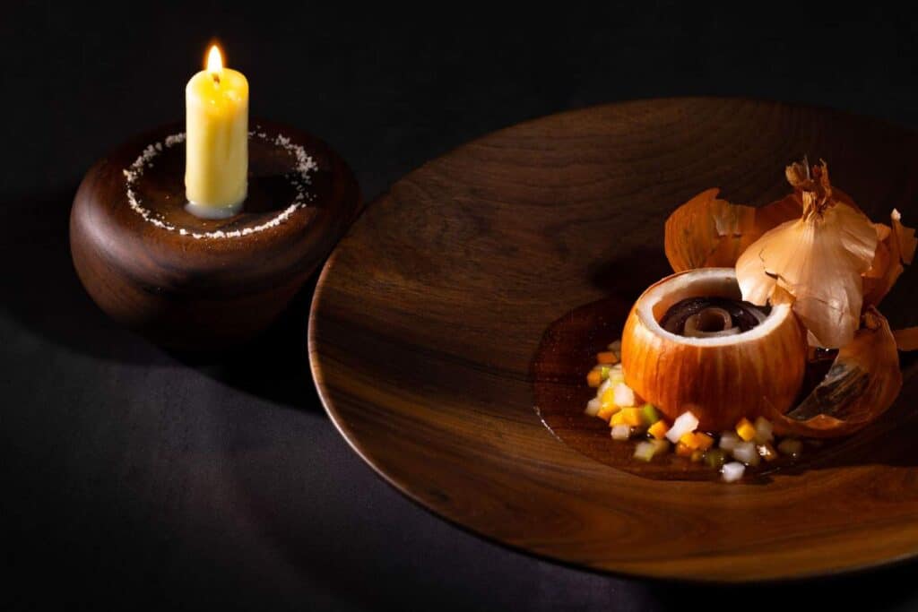 An onion dish served with a candle