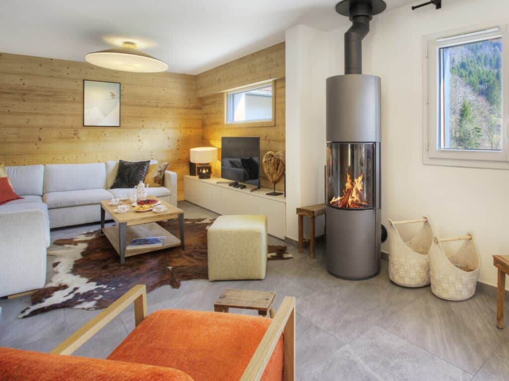 A modern circular wood-burning stove in the living room of Chalet Ysopi