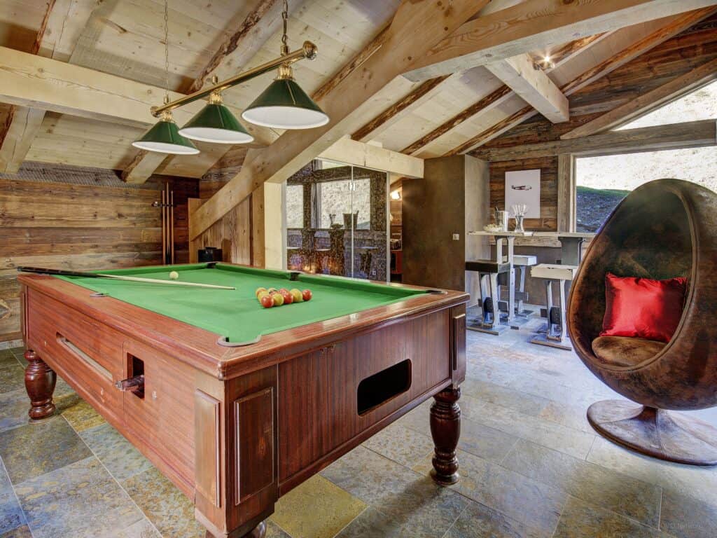 The games room with a pool table cosy 'egg' chairs and a bar