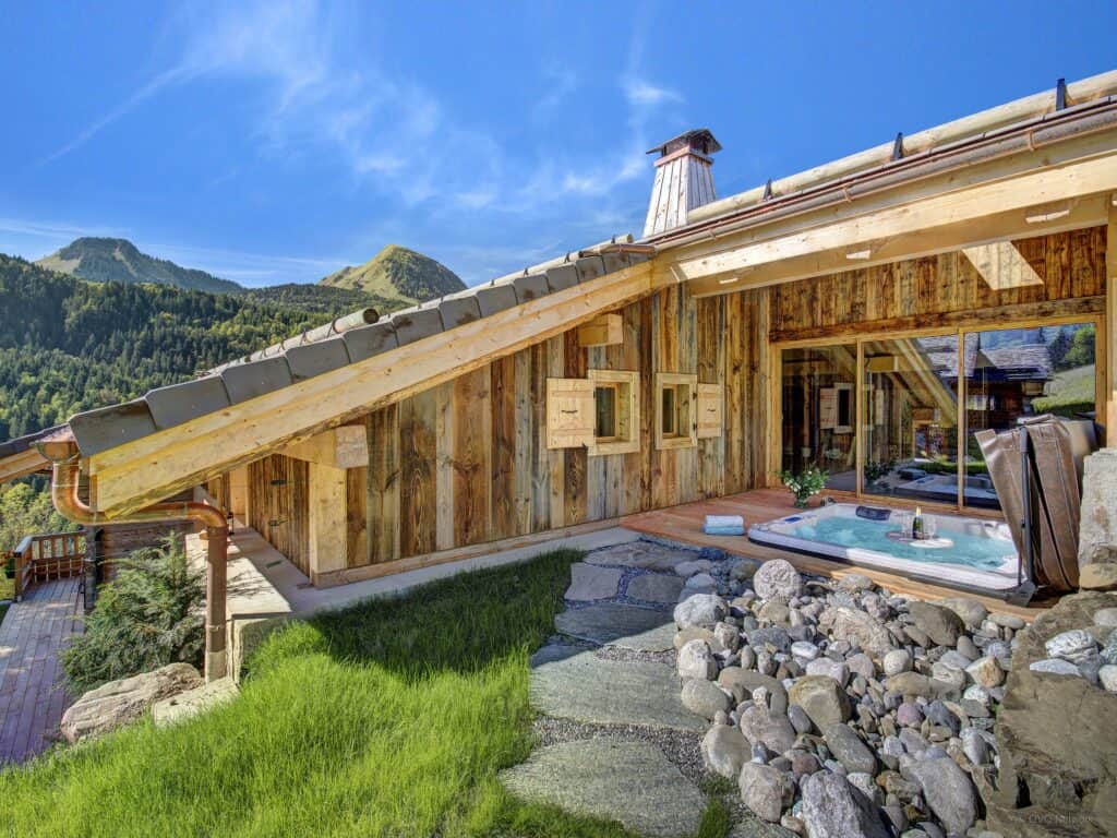 The wooden terrace with a hot tub at Chalet Les Brevins