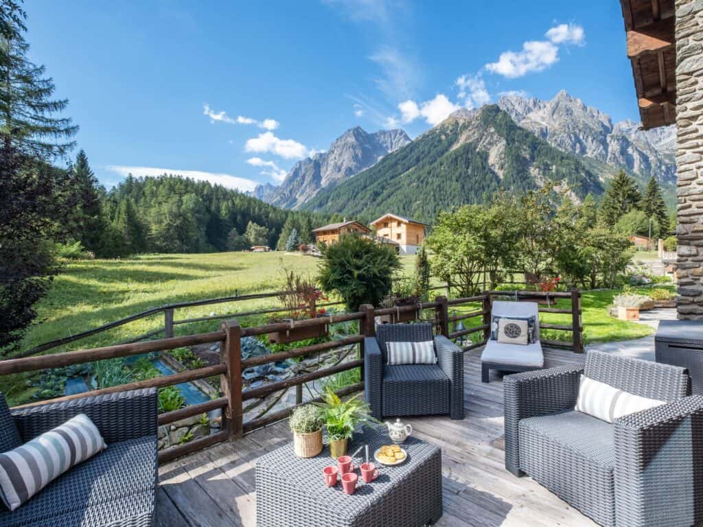 A furnished terrace next to a pond with a view of the mountains
