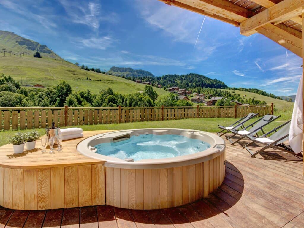 The beautiful hot tub at Chalet Meringue, with deck chairs, champagne towels and a great view
