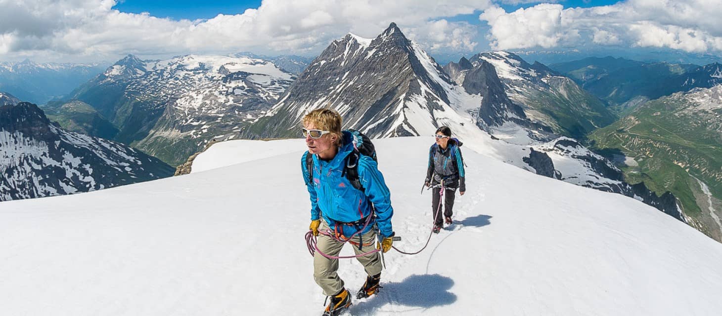 Un homme et une femme encordés marchent sur la neige dans le Glacier de la Grande Motte. 