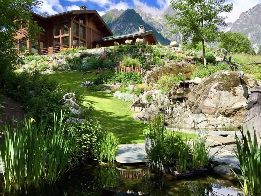 The lush green garden with mountains in the background at Chalet Cinq Moutons
