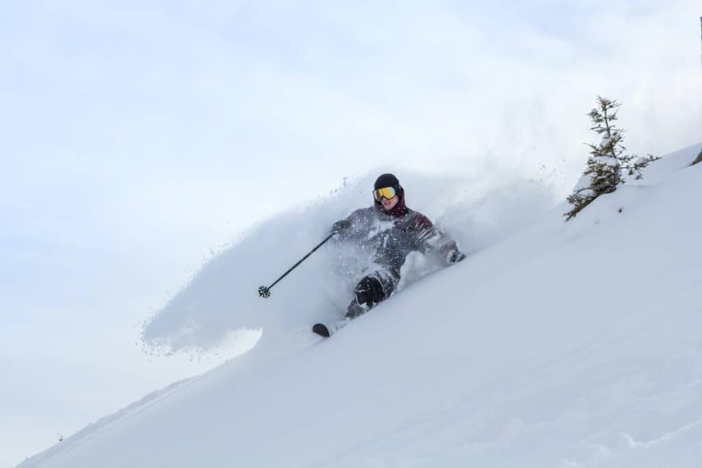 A man skis through fresh powder snow