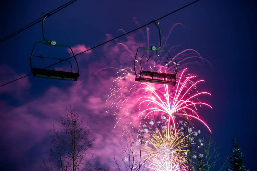 Firework display behind a chair lift in a ski resort