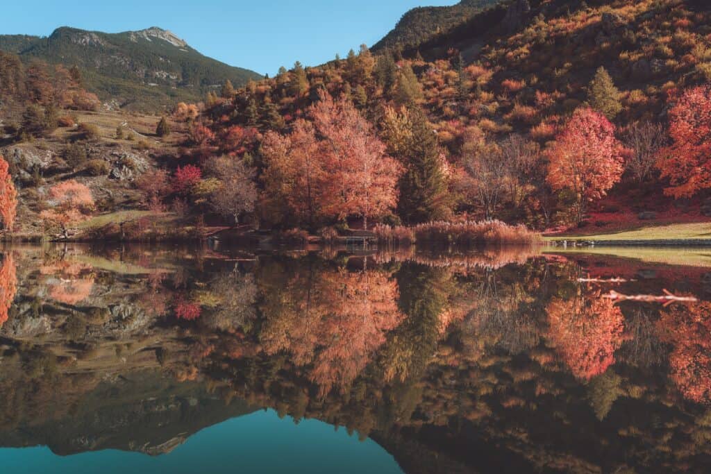 Lake in Chamonix with autumnal trees reflecting in the water