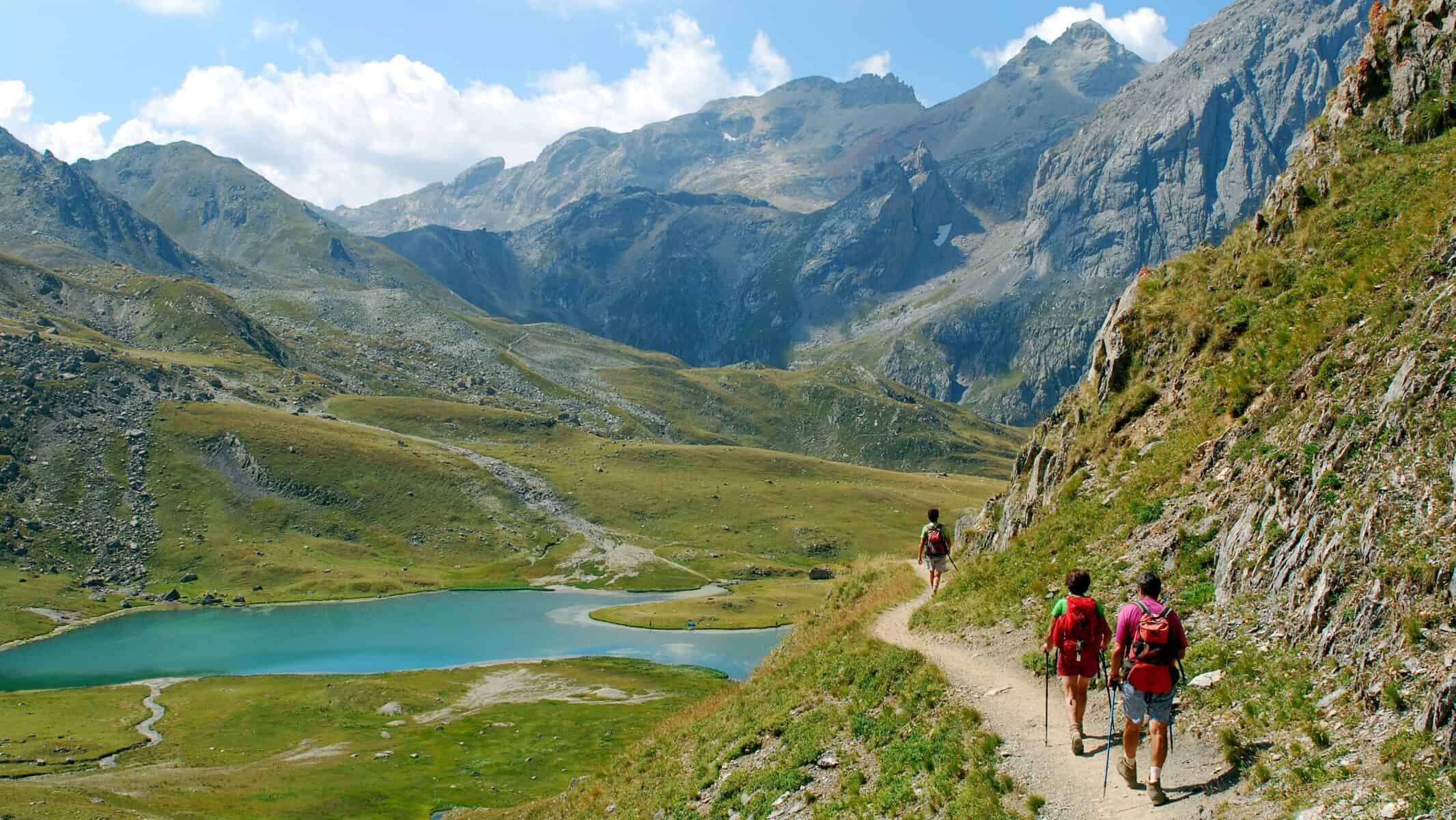 Trois personnes au détour d'une randonnée entre lacs et montagnes, au coeur des Alpes.