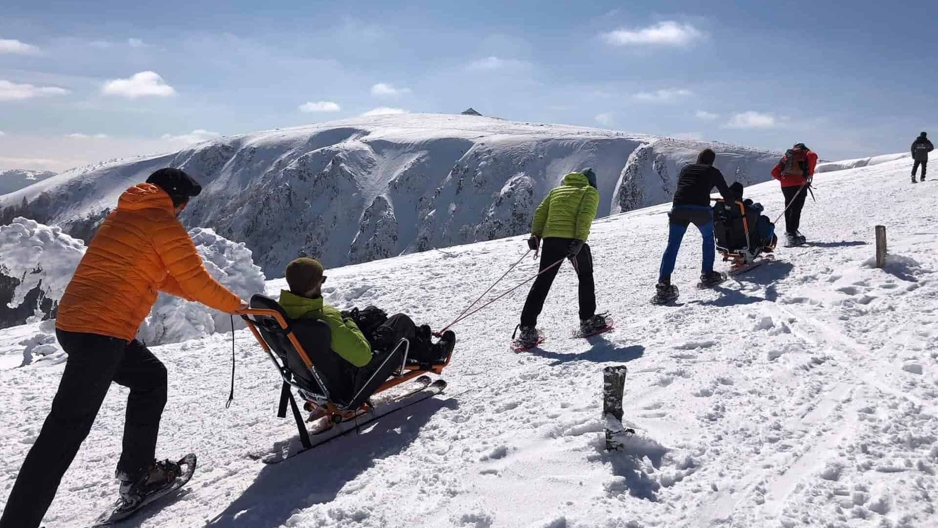Rescuers help injured hikers in the high mountains in the snow.
