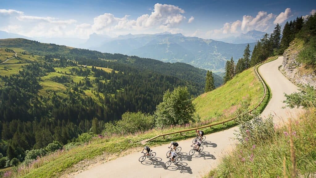 A group of cyclists speed down a mountain road