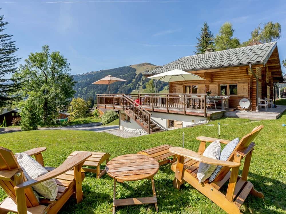 Wooden chairs and a table in the garden of Chalet Joux Verts