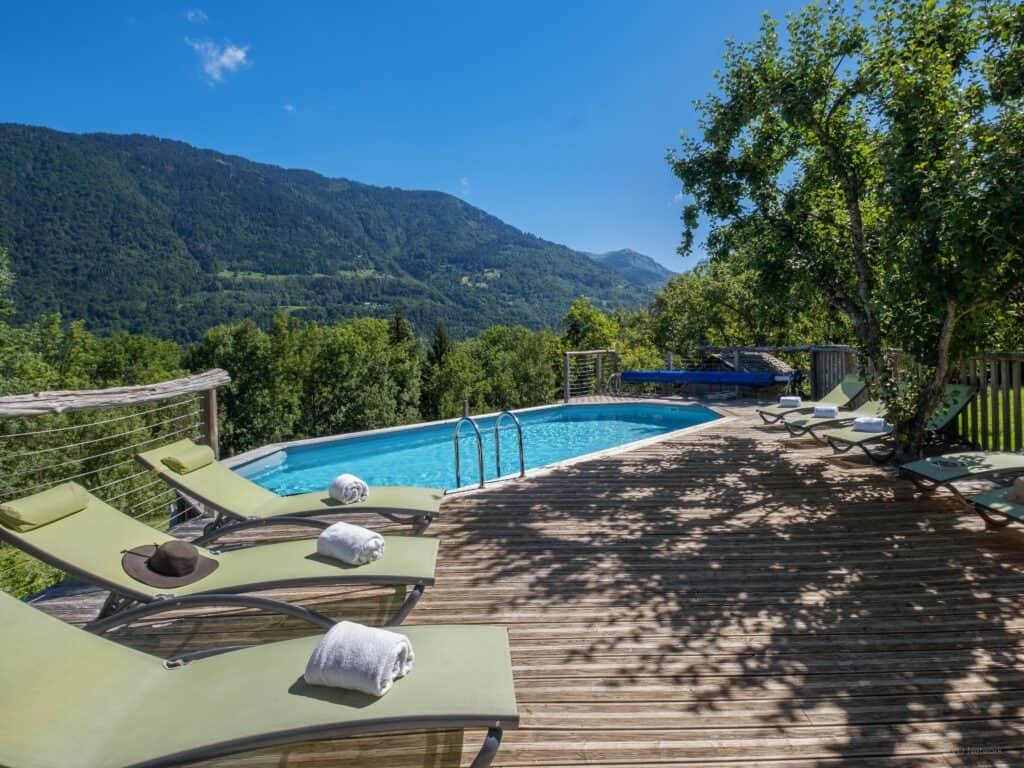The swimming pool and sunbeds on the terrace of Chalet Keramis, with a view of the mountains