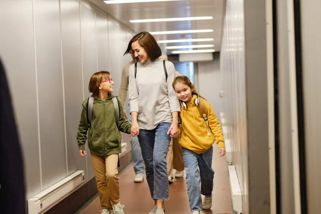 Une maman heureuse avec deux enfants marchant dans un terminal d'aéroport