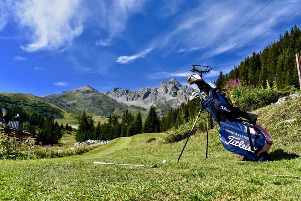 Caddie de golf et son club face aux montagnes.