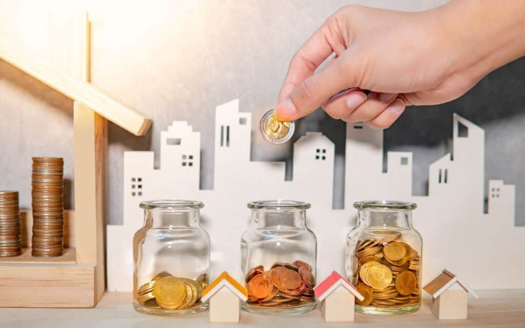 A hand depositing coins in jars