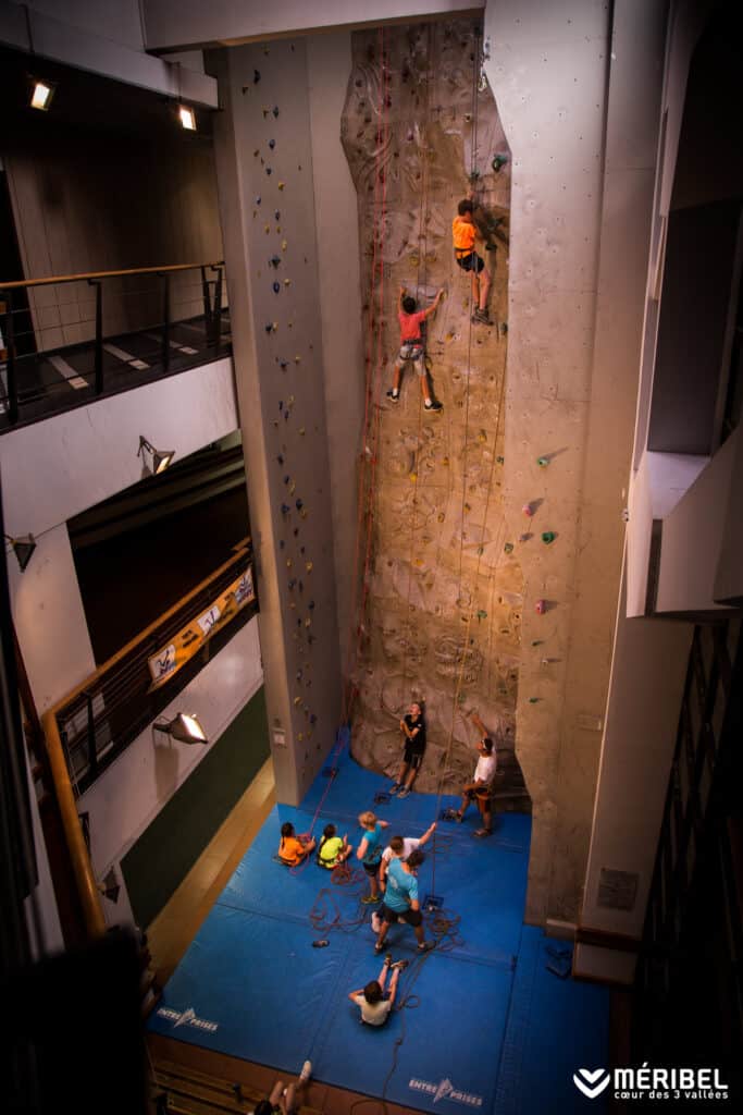Children climb an indoor climbing wall