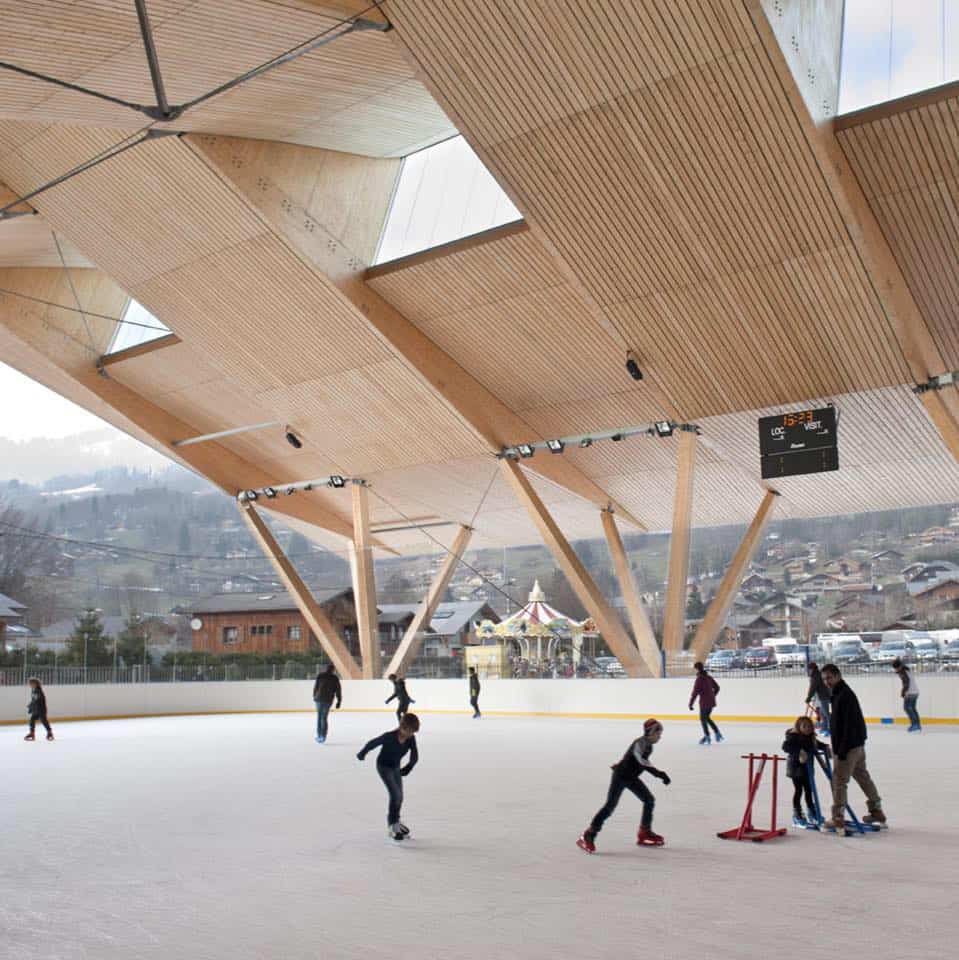 People skate around a covered ice rink in the mountains