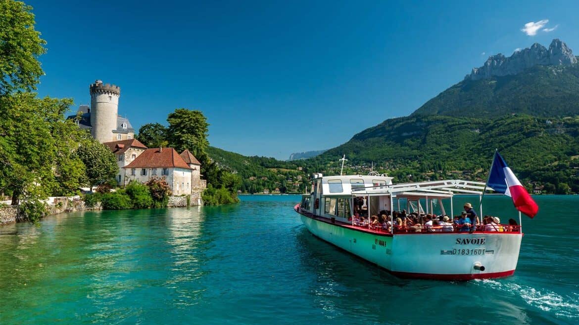A tourist boat passes the Château de Duingt, overlooking Lake Annecy
