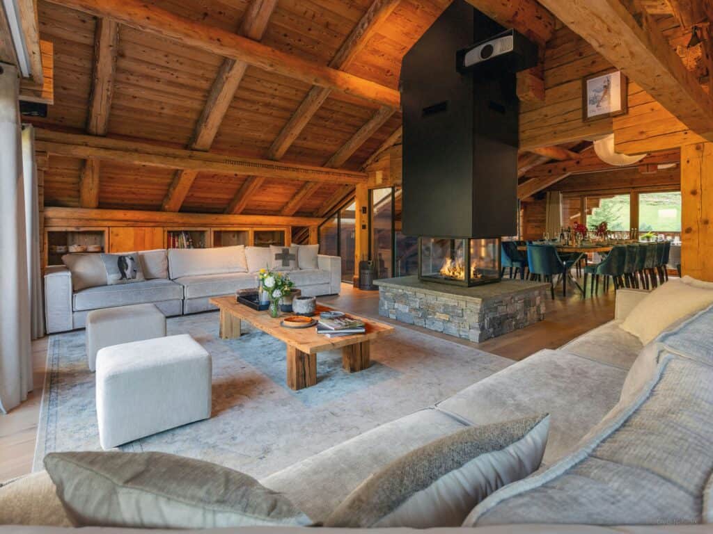 Cosy chalet living room with a lit up fireplace.