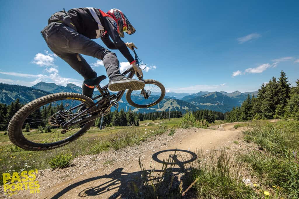 Un homme en vélo de montagne fait un saut.