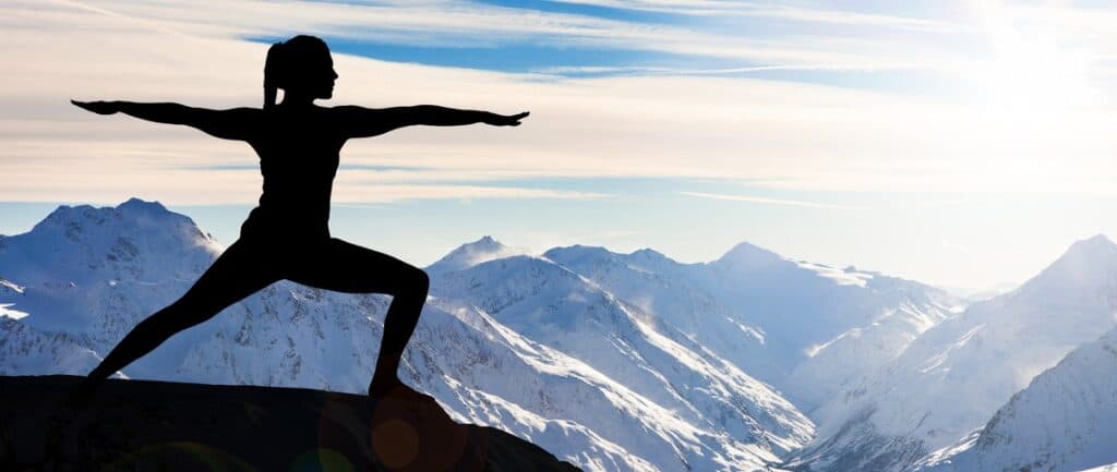 Femme faisant du yoga en montagne, face aux glaciers.