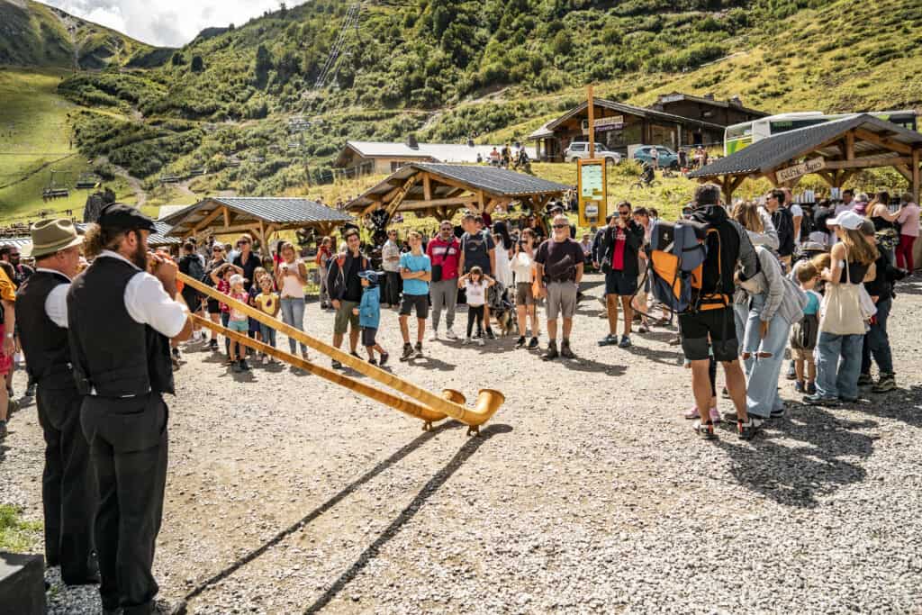 Deux hommes jouent du cor des Alpes pour les spectateurs.