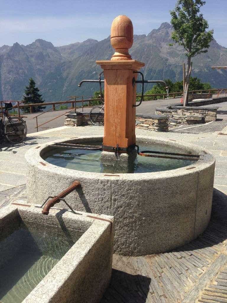 A granite waterpump and trough, with the mountains in the background