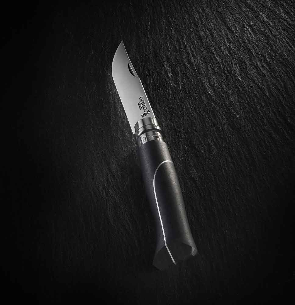 An Opinel knife with a black handle and a grey line, set against a black background.