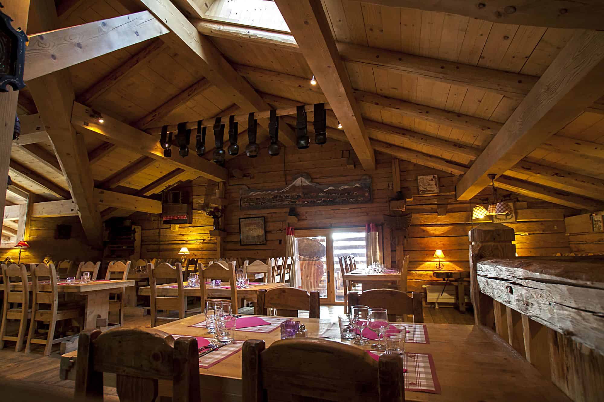 A restaurant dining room laid for dinner on the top floor of a wooden chalet