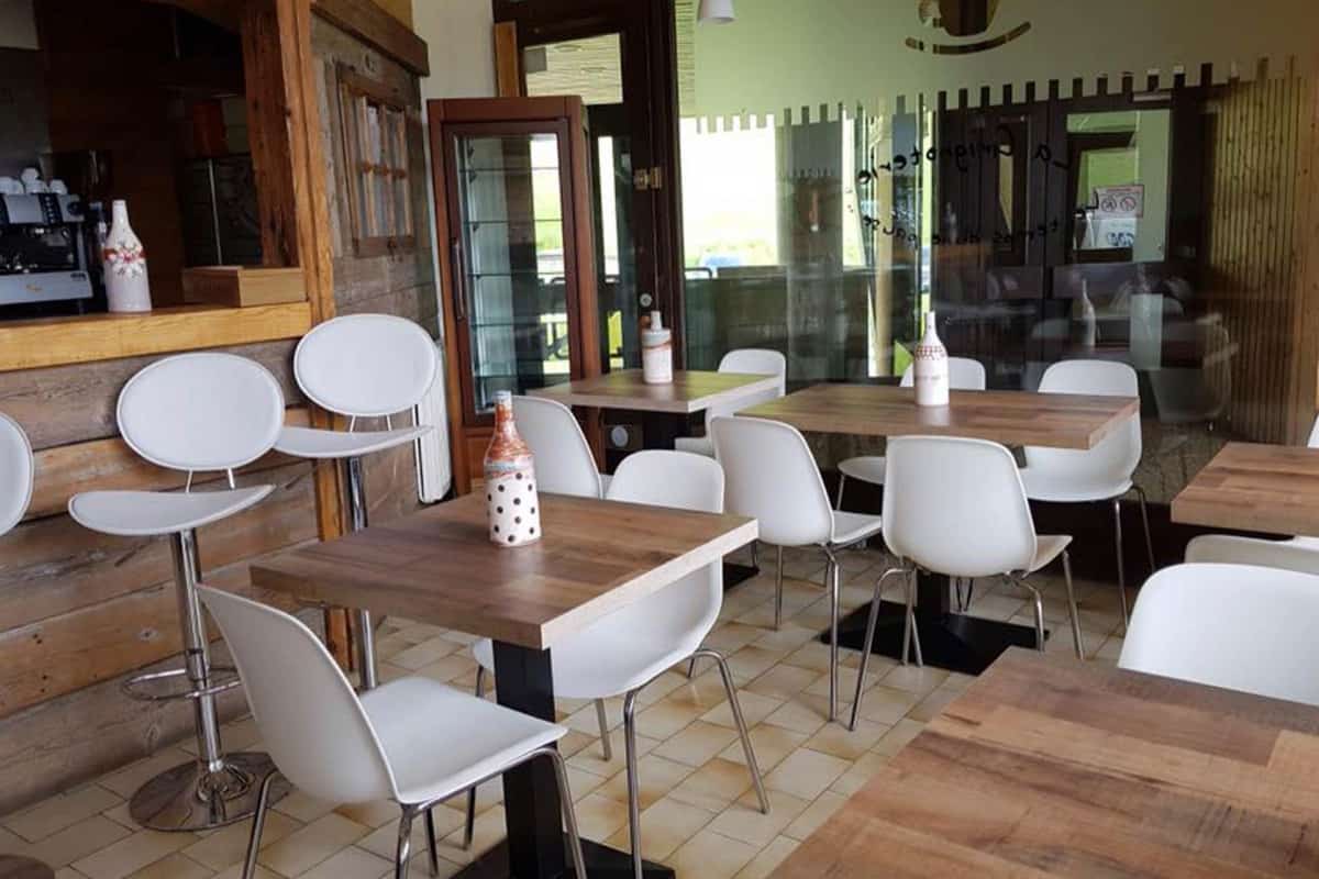 White chairs and wooden tables in a simple restaurant setting