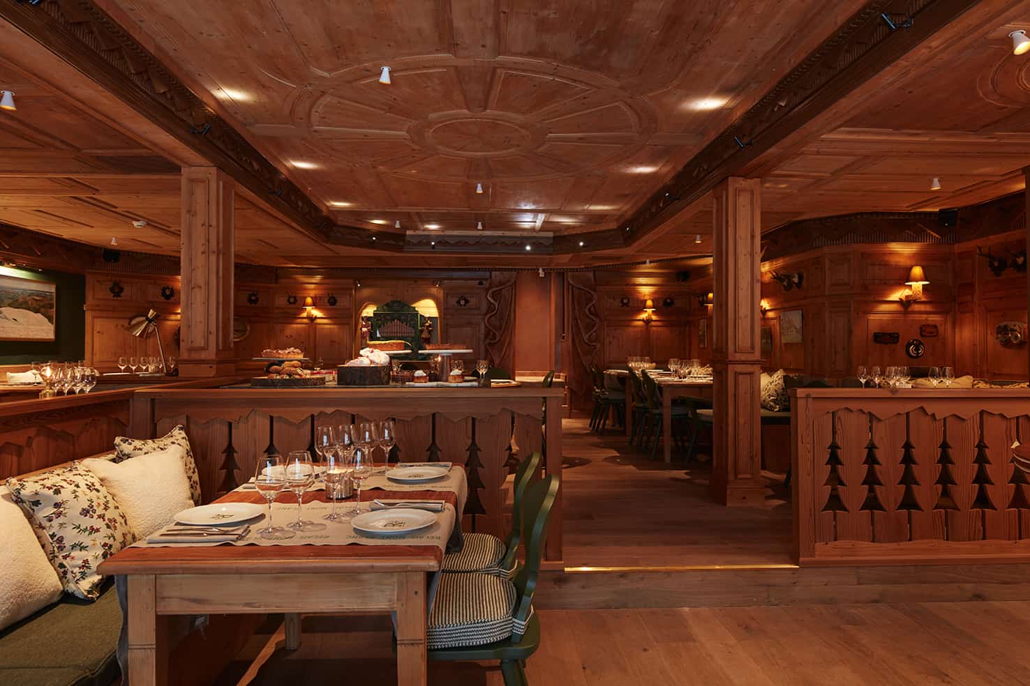 Interior of a restaurant with its tables set and ceiling lights.