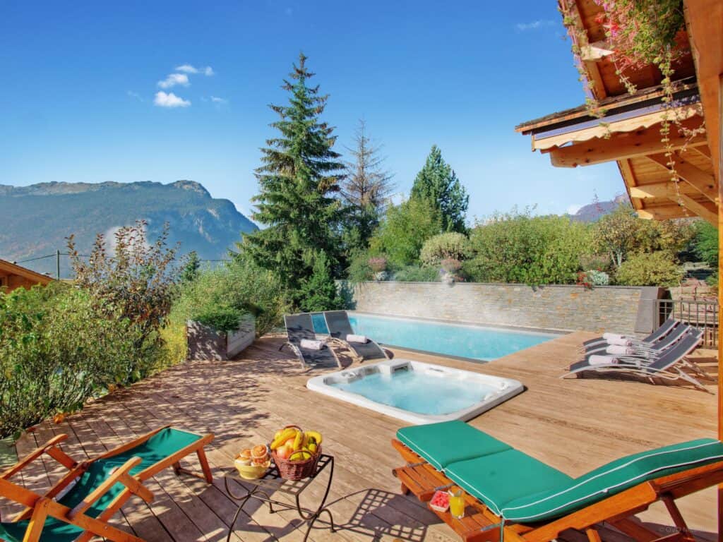 Sunbeds around the hot tub and pool at Chalet Beauvoir 12