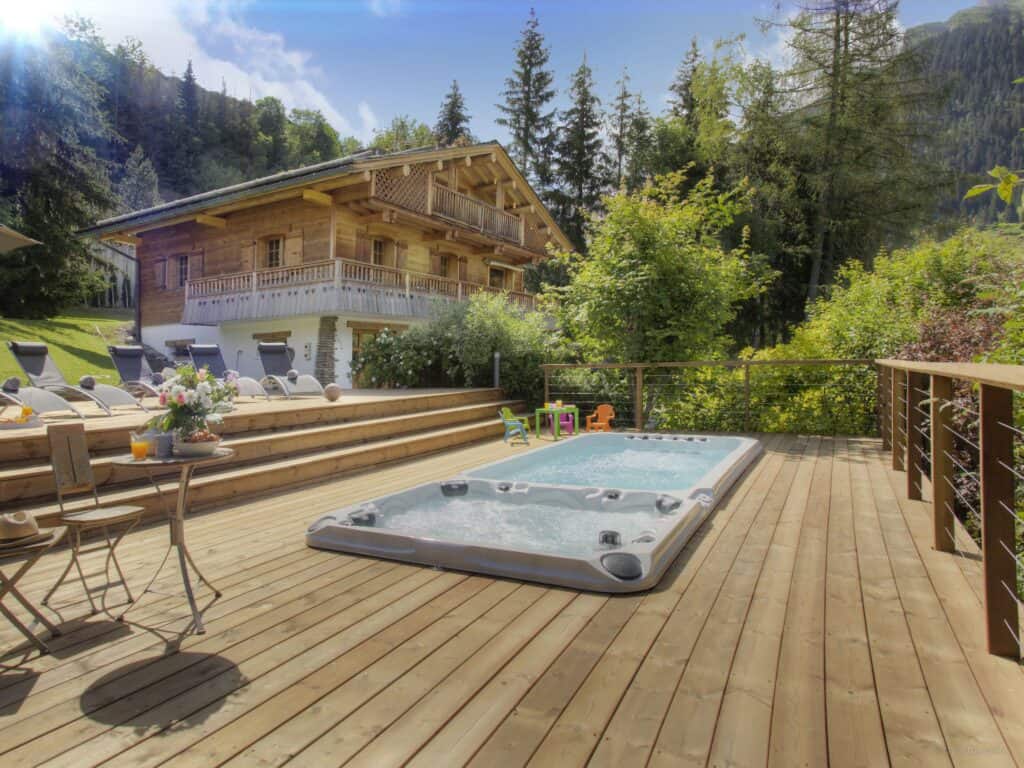 Piscine extérieure avec bain à remous et terrasse ensoleillée