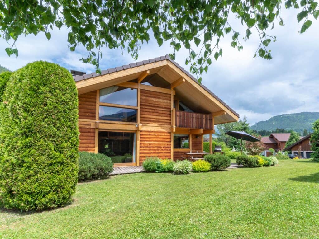 Façade de chalet en bois et pelouse.