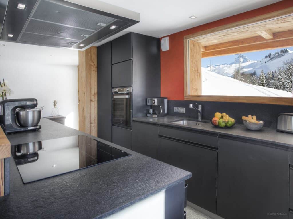 Cuisine sombre avec fenestre sur montagne.