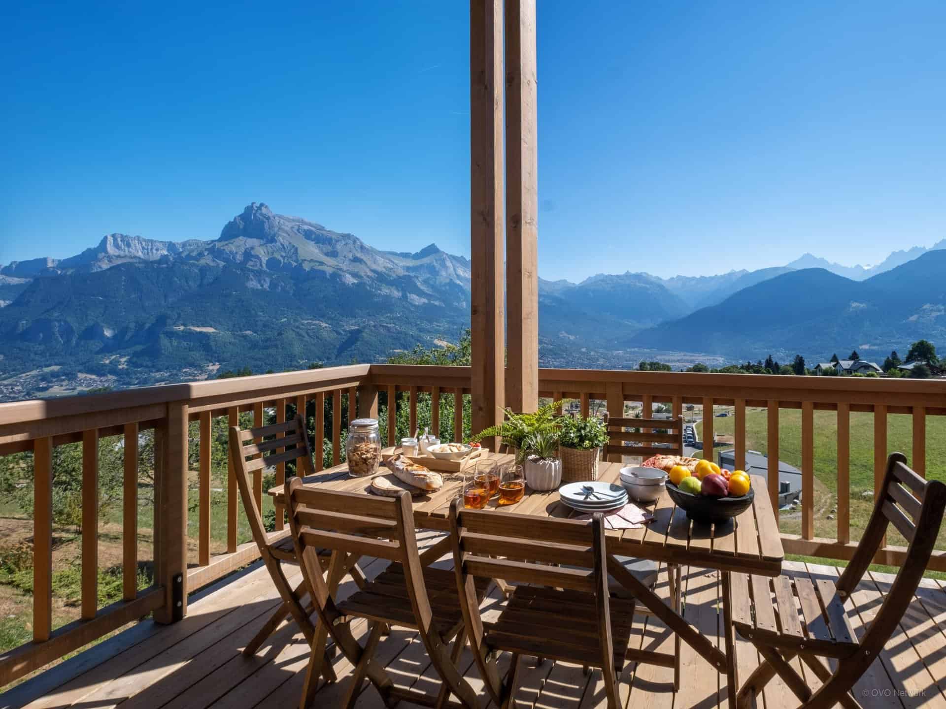A table is laid for a meal on a sunny terrace in the mountains