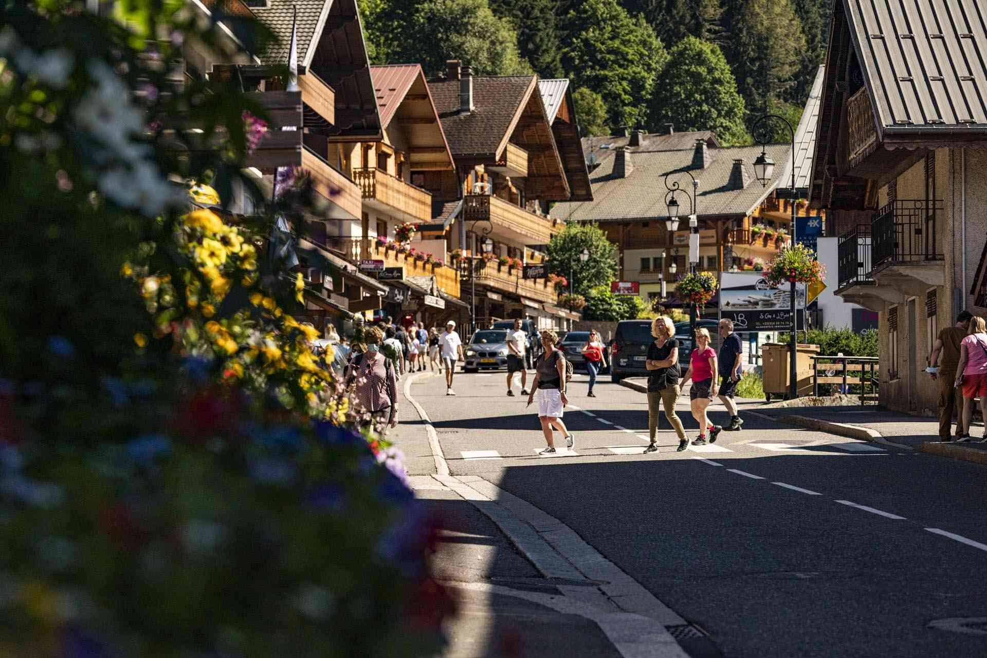 Visitors wander around a pretty mountain resort in summer