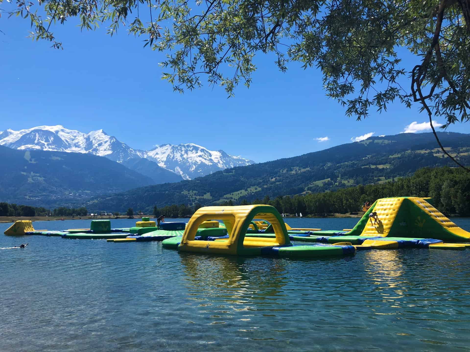 An inflatable and floating assault course at Lac de Passy, with mountains in the background