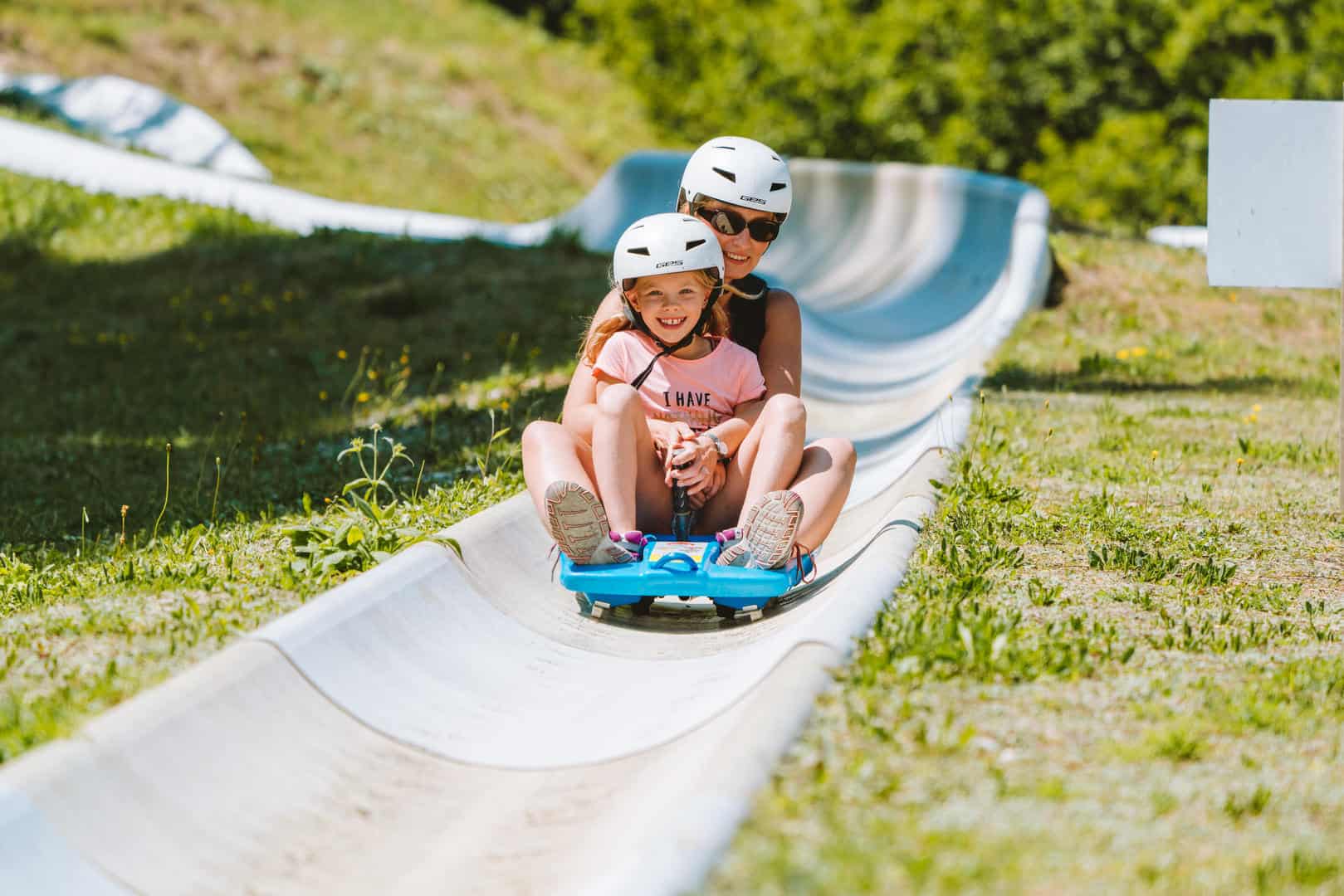 A woman and her daughter on the summer sledge 