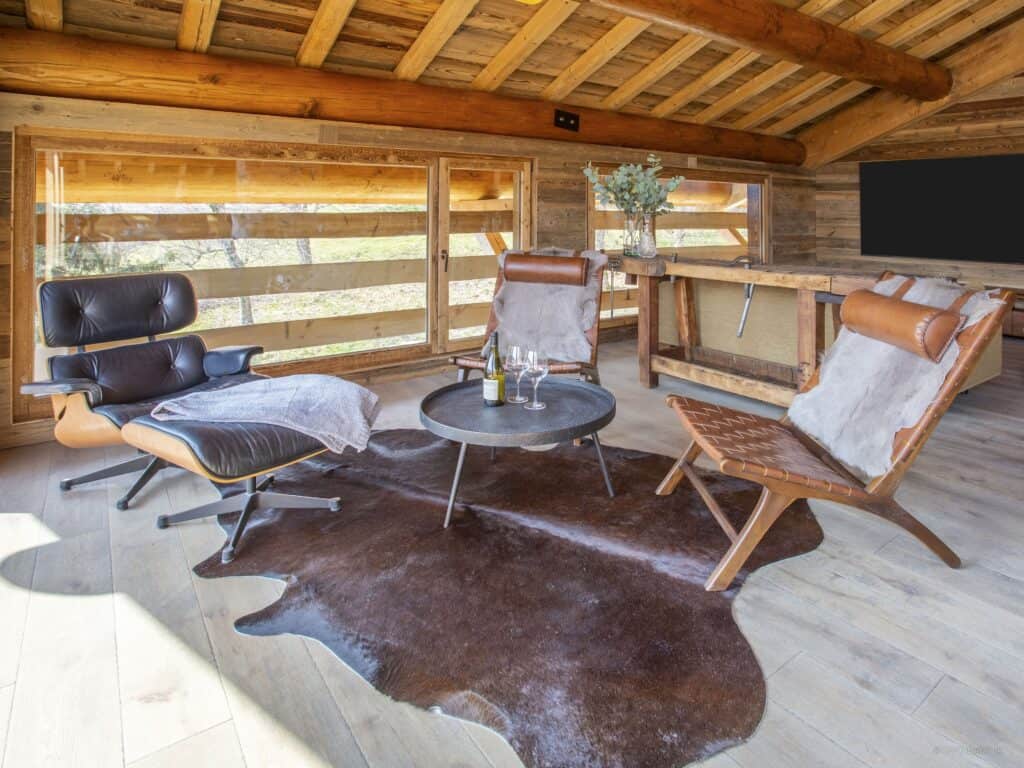 Three leather chairs are placed aroudn acoffee table at La Ferme de Mila