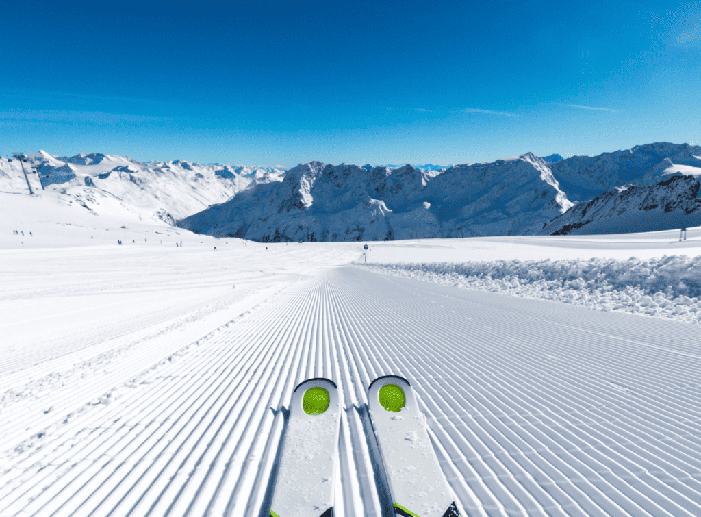 A pair of skis at the top of a groomed piste