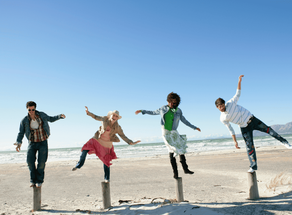 Four people test their balance on the beach