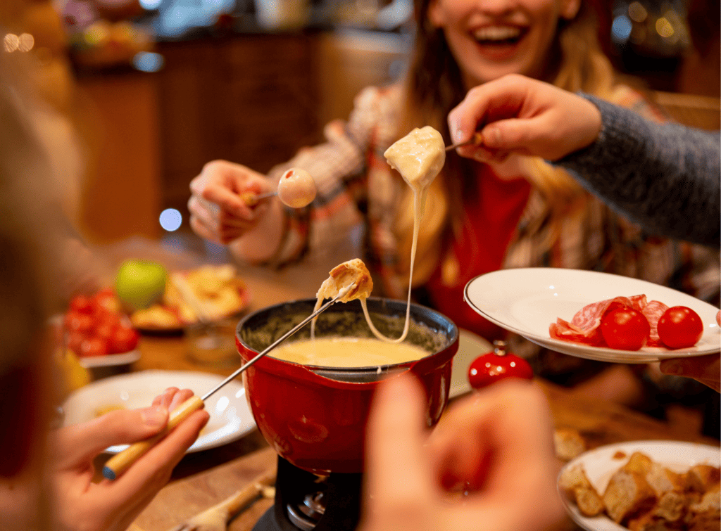 Personnes partageant une fondue savoyarde.