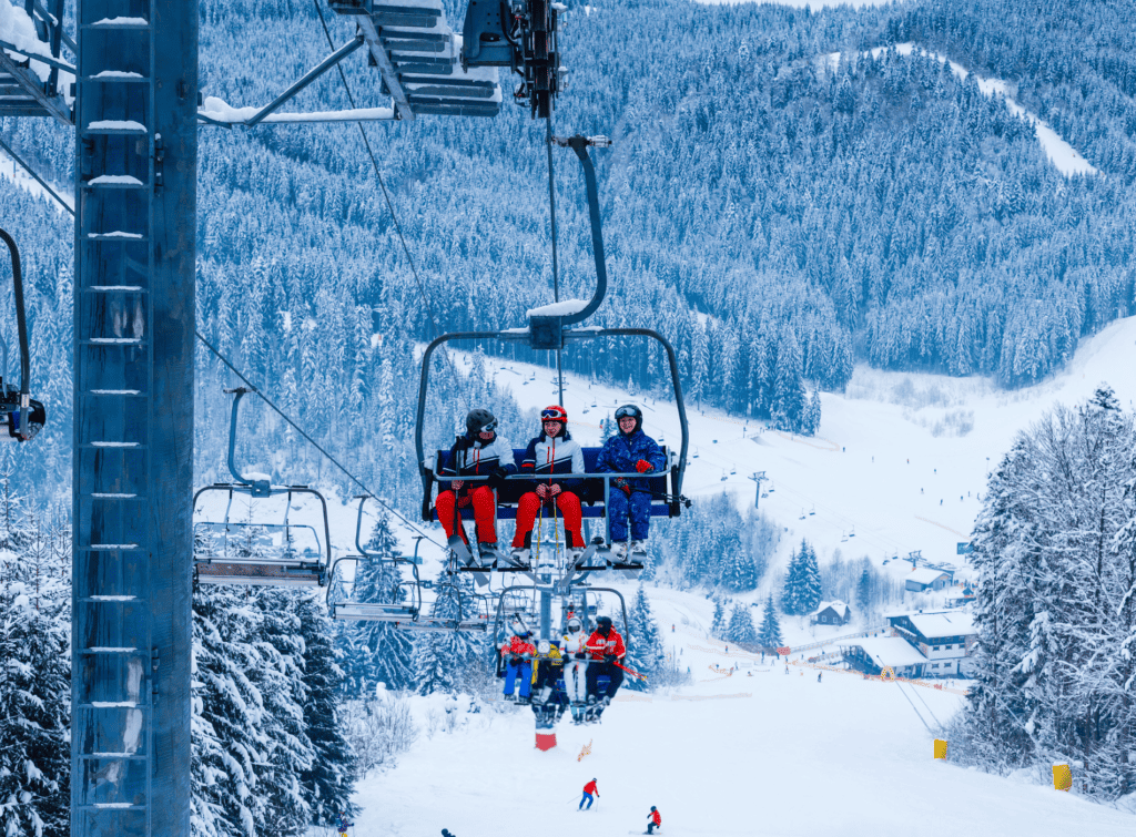 Skiers travelling on a chairlift over the slope