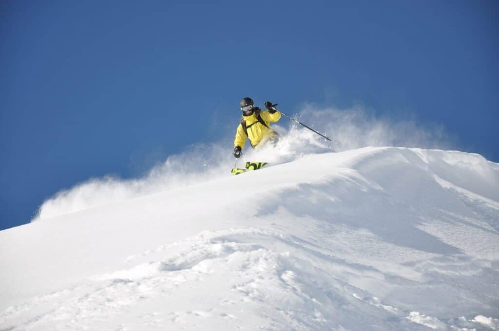 Skieur en train de skier dans de la poudreuse. 